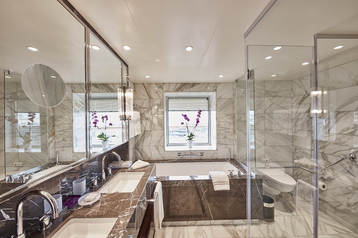 Luxurious marble bathroom with a bath tub and shower on-board Cunard Queen Victoria