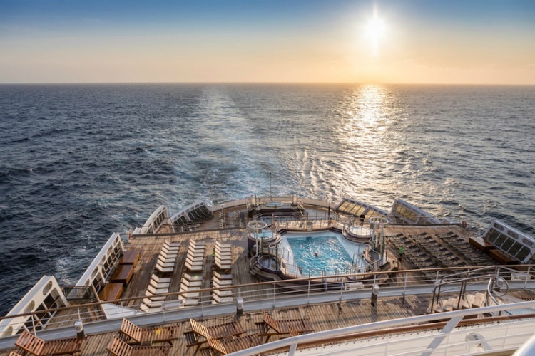 The pool deck of Cunard's Queen Mary 2 at sunset